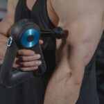 Een massage gun op een tafel, klaar voor gebruik om spierspanning te verlichten en comfort te bieden.